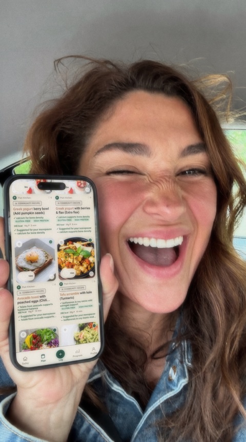 Savannah, a Plait Health member, holding her phone showing community recipes
